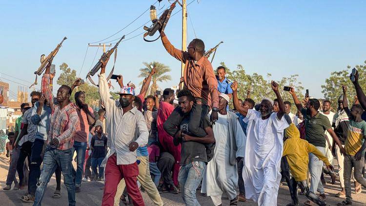 Men rallying with rifles in Wad Madani, Sudan, in December 2023. 