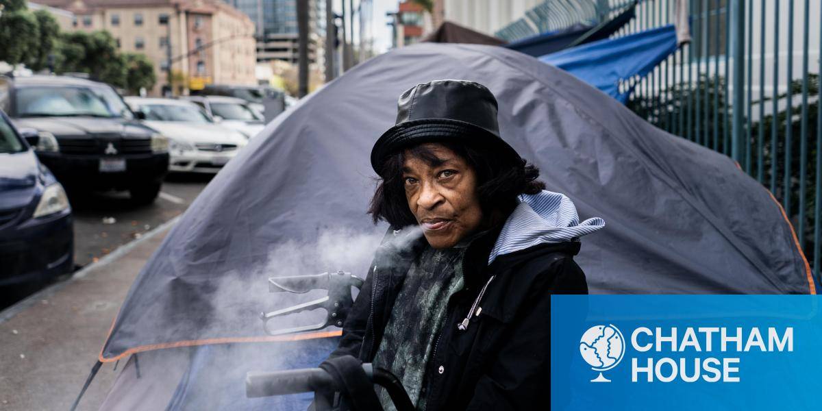 homeless woman sits outside tent smoking fentanyl